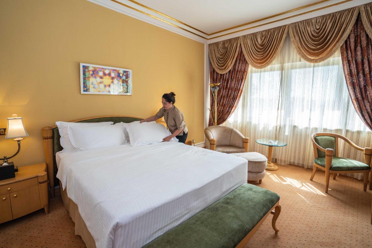 Officers Club & Hotel Абу Даби Екстериор снимка A chambermaid making a bed in a hotel room
